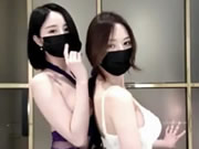 Duas belas raparigas asiáticas dançam usando máscaras